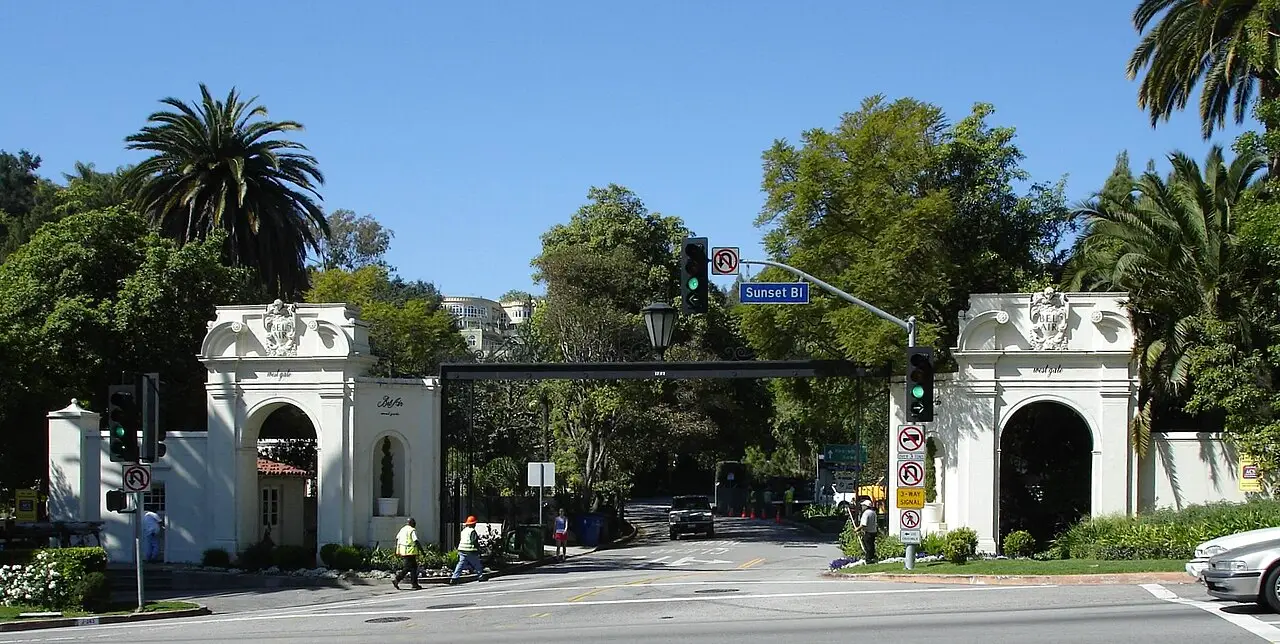 Bel Air's ornate white entrance gates off Sunset Boulevard, flanked by palms