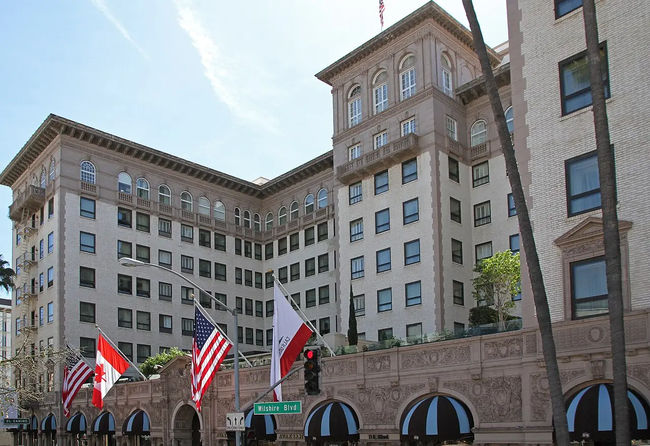 Historic hotel facade with striped awnings and flags on Wilshire Boulevard in Beverly Hills