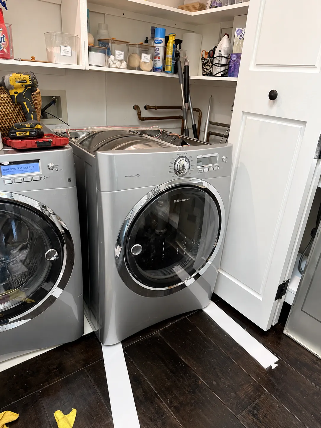 Front loading clothes dryer with the door open in a laundry room