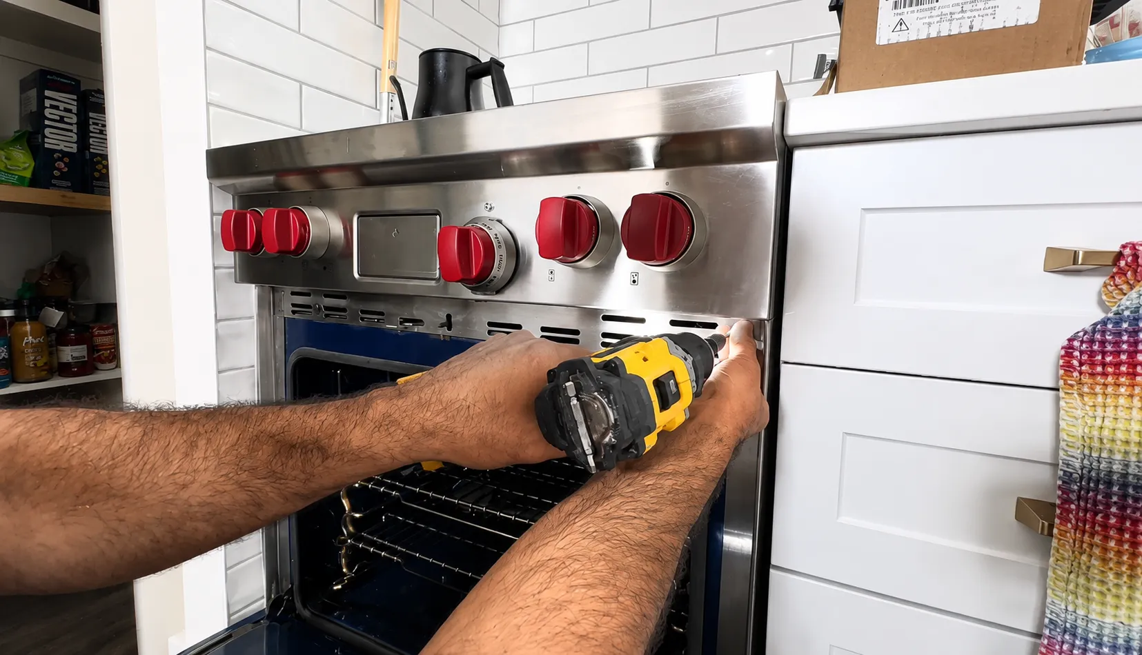 A technician removing the control fascia of a red knob professional range