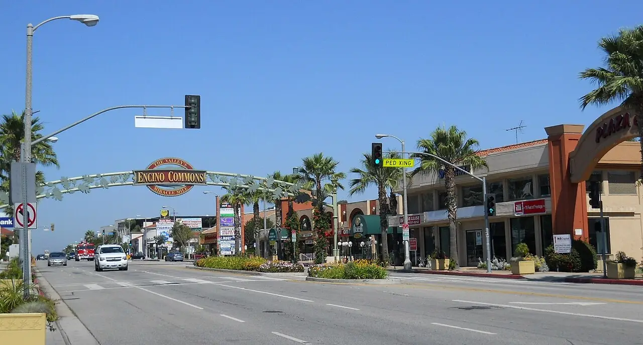 Encino Commons archway over Ventura Boulevard storefronts and palms