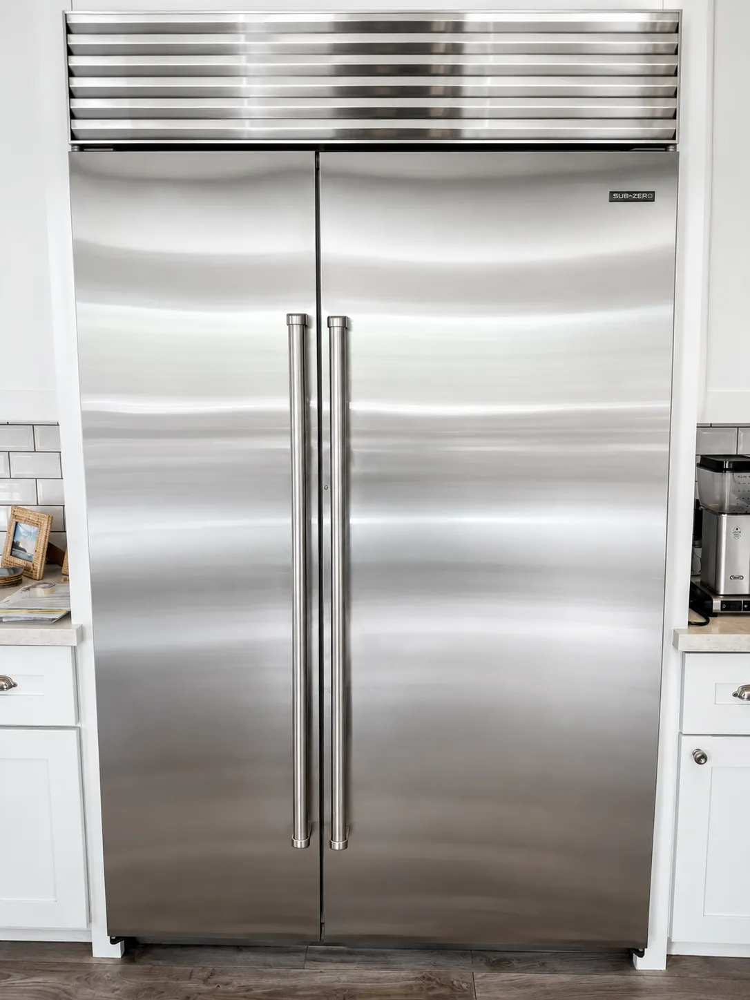 Stainless Sub-Zero built in side by side refrigerator with a louvered grille