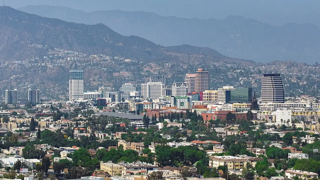 Downtown Glendale's mid-rise skyline above leafy residential blocks, mountains behind