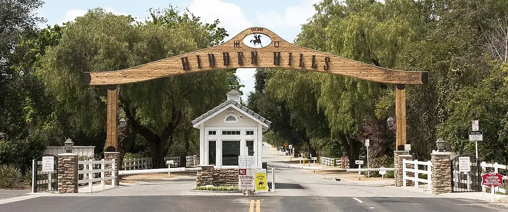 The rustic wooden Hidden Hills entrance arch and guard booth at the community gate