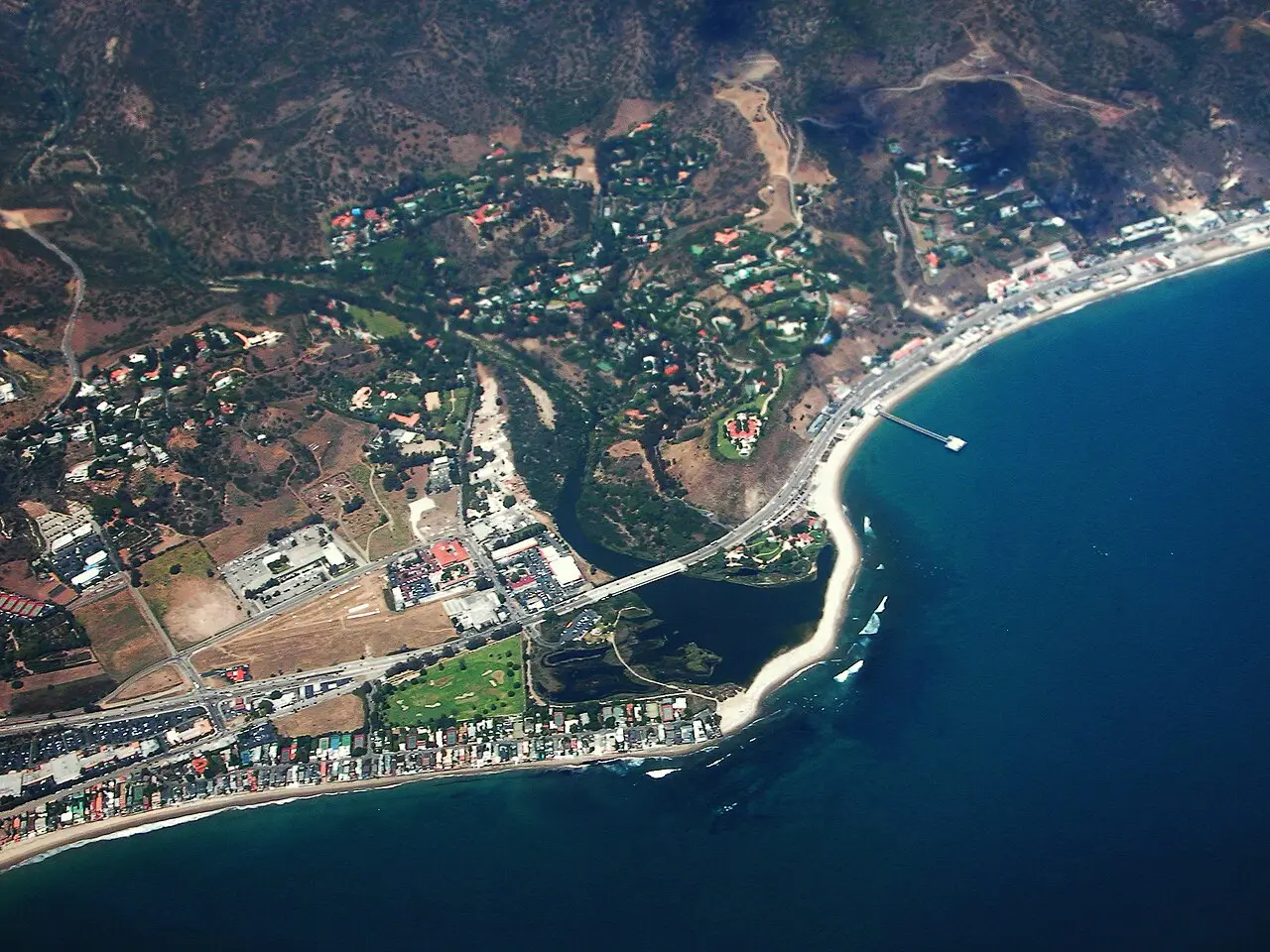 Malibu's coastline from above, beachfront homes, the pier, and the lagoon meeting the Pacific