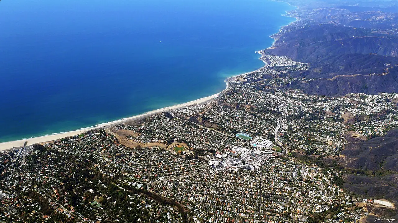 Pacific Palisades neighborhoods stacked above the curving coastline and beach