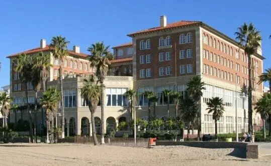 Historic red-tile-roofed beachfront hotel above the sand in Santa Monica