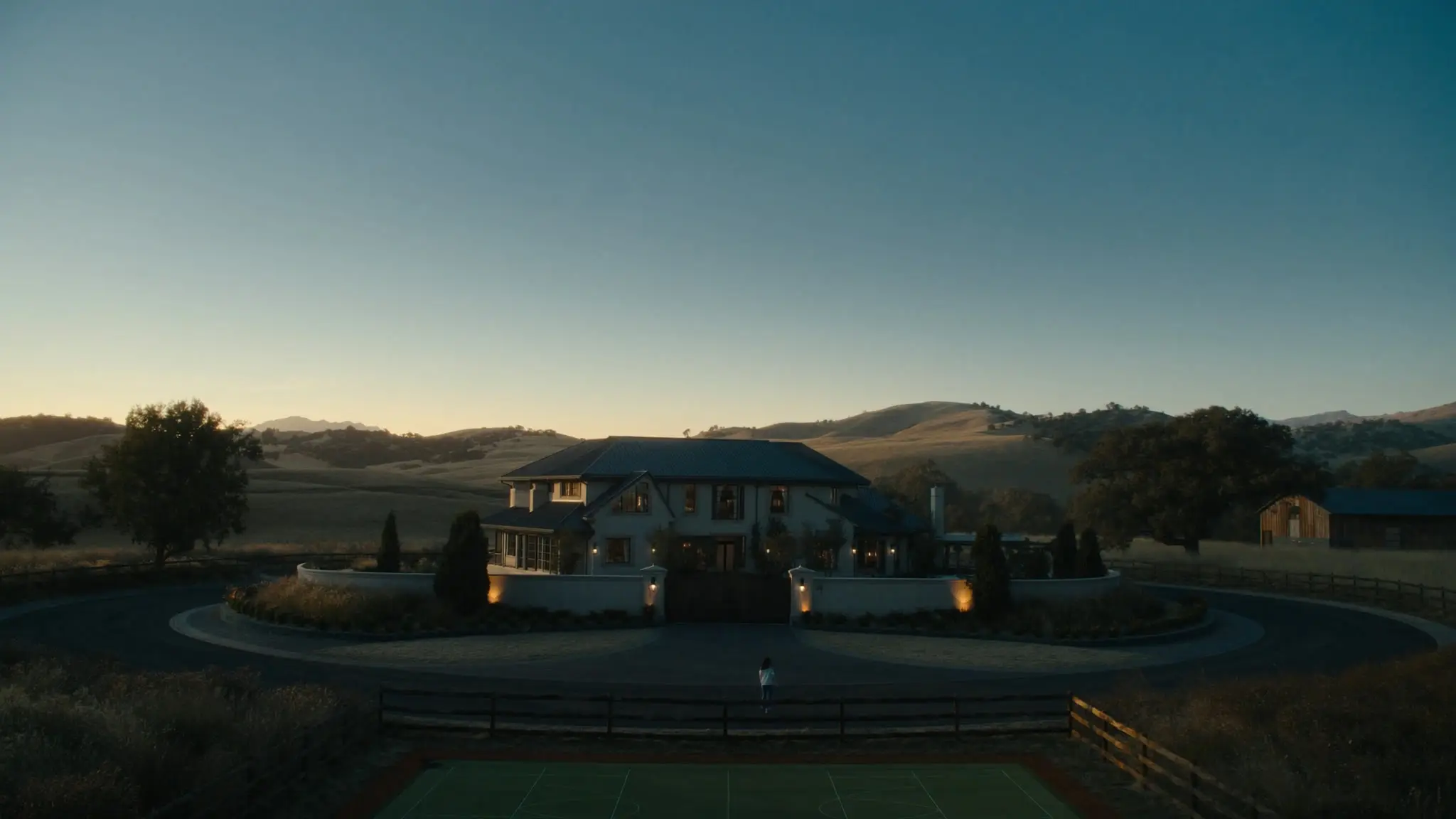 Gated Simi Valley estate with a circular drive amid golden rolling hills at dusk