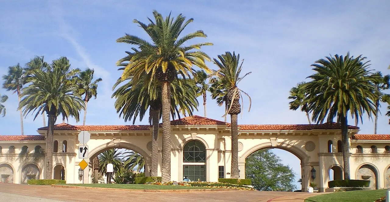 Mediterranean arched gateway with a red-tile roof and palms in Tarzana