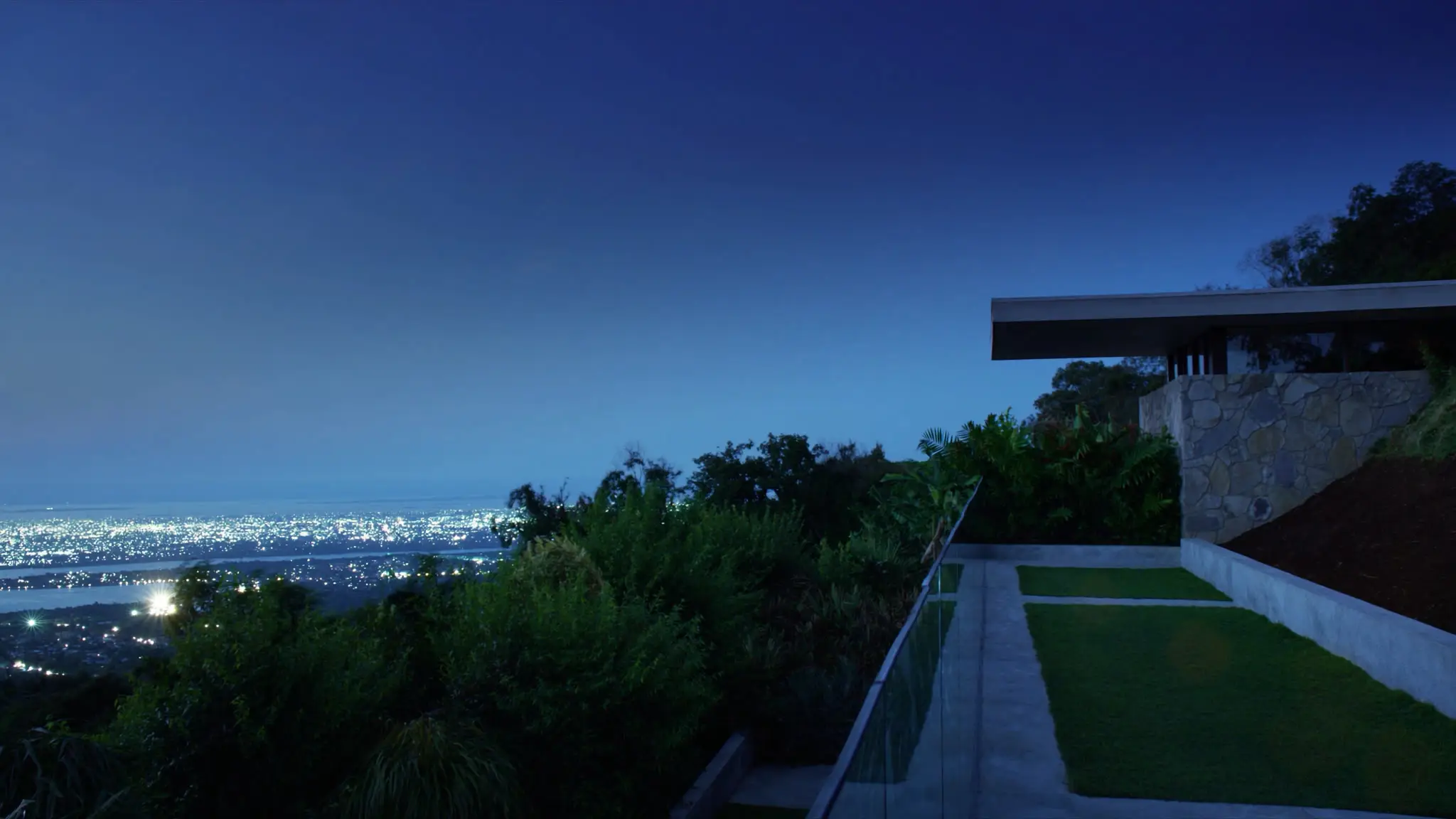 City lights at blue hour from a glass-railed Westchester hillside terrace
