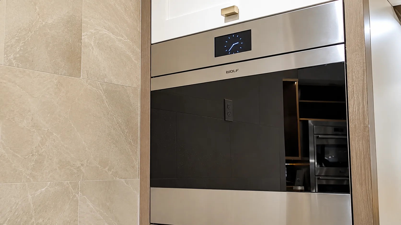 Built in Wolf wall oven with a black glass front in a modern kitchen